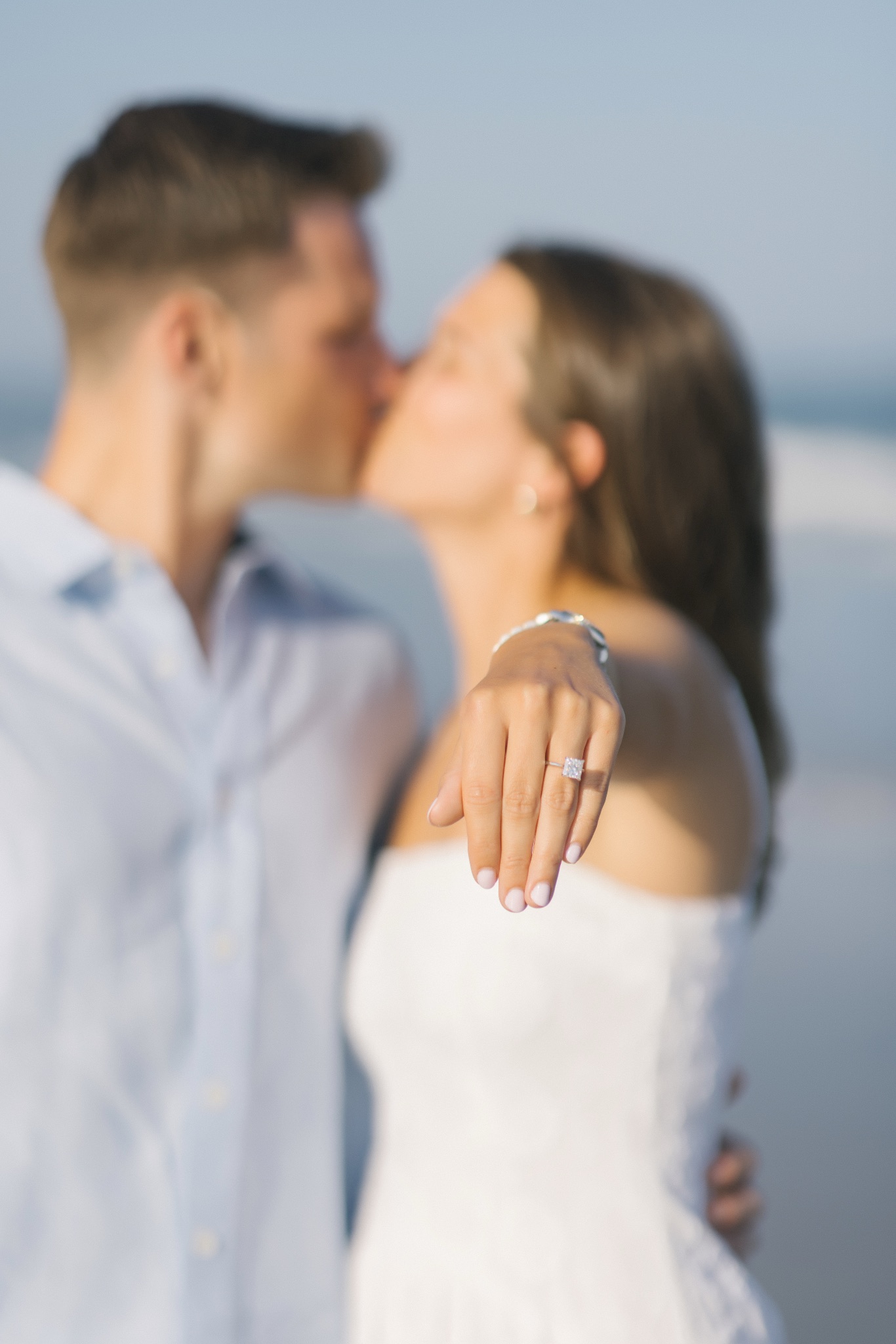 Katie and Chris kissing as she shows off her engagement ring in Stone Harbor, New Jersey
