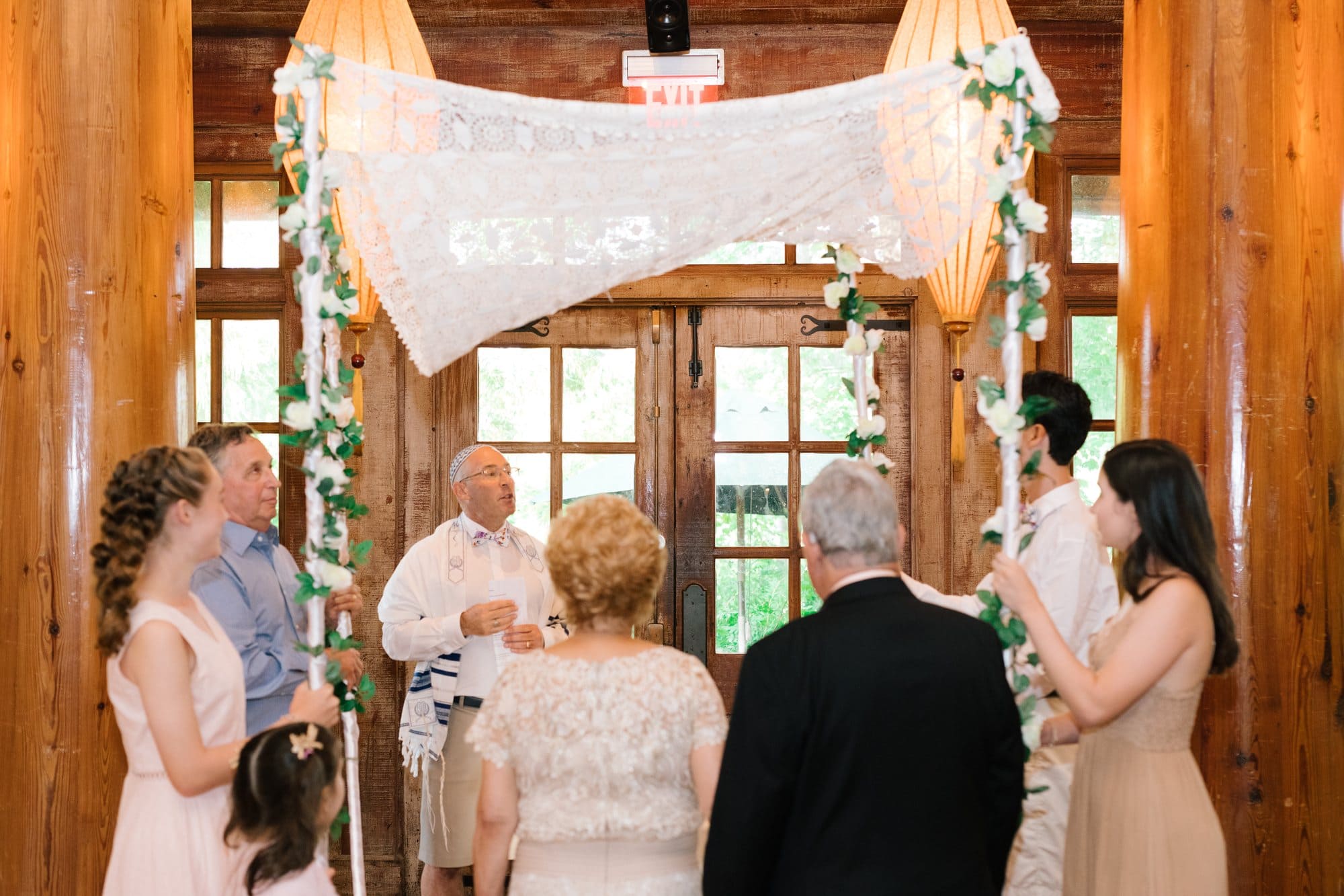 A vow renewal ceremony under a chuppah with family gathered at Grounds for Sculpture in New Jersey