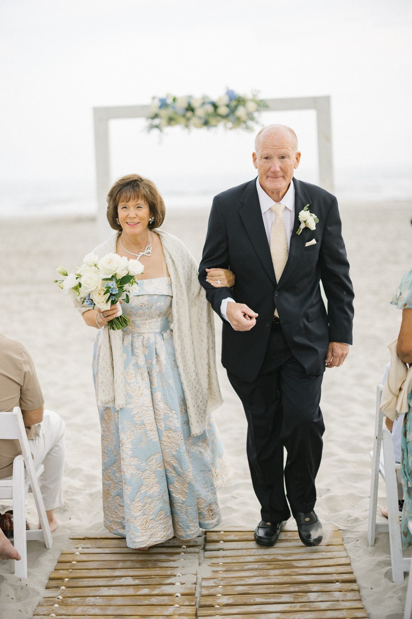 A couple walking back up the sand after their beach vow renewal in Avalon, New Jersey