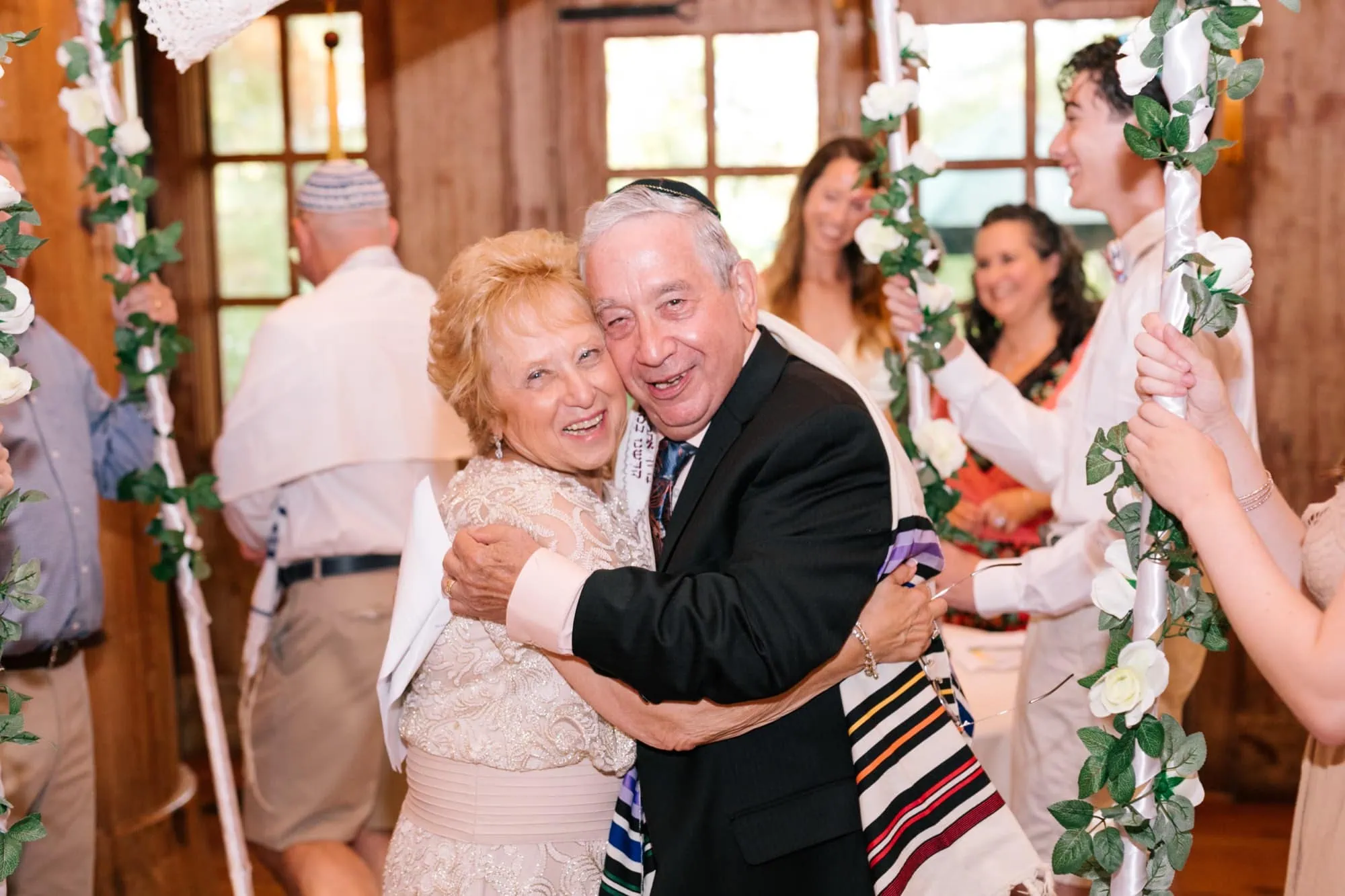 An older couple laughing in an embrace after their fiftieth anniversary vow renewal in New Jersey