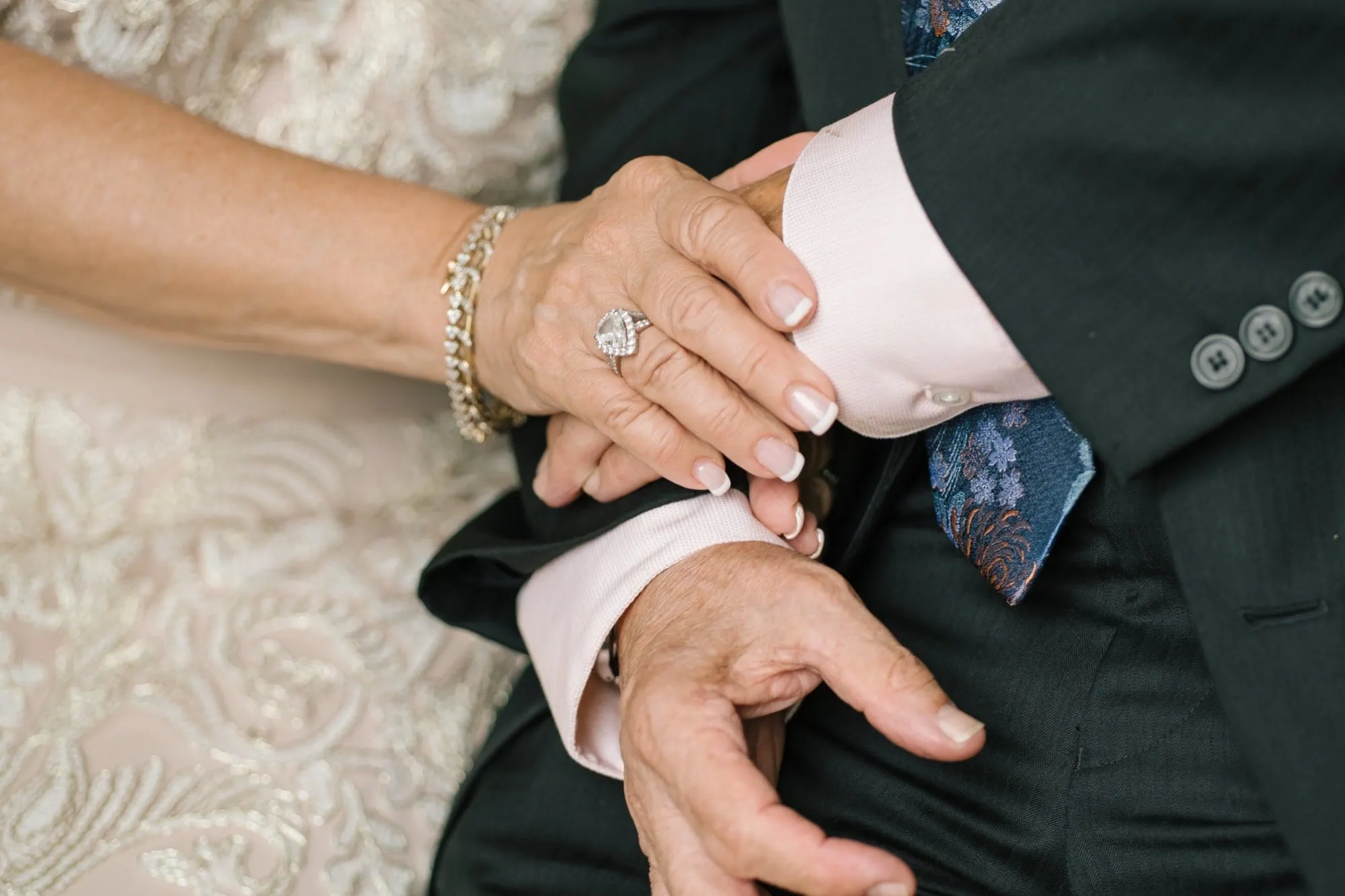 A close view of an older couple's hands and wedding rings during a fiftieth anniversary vow renewal