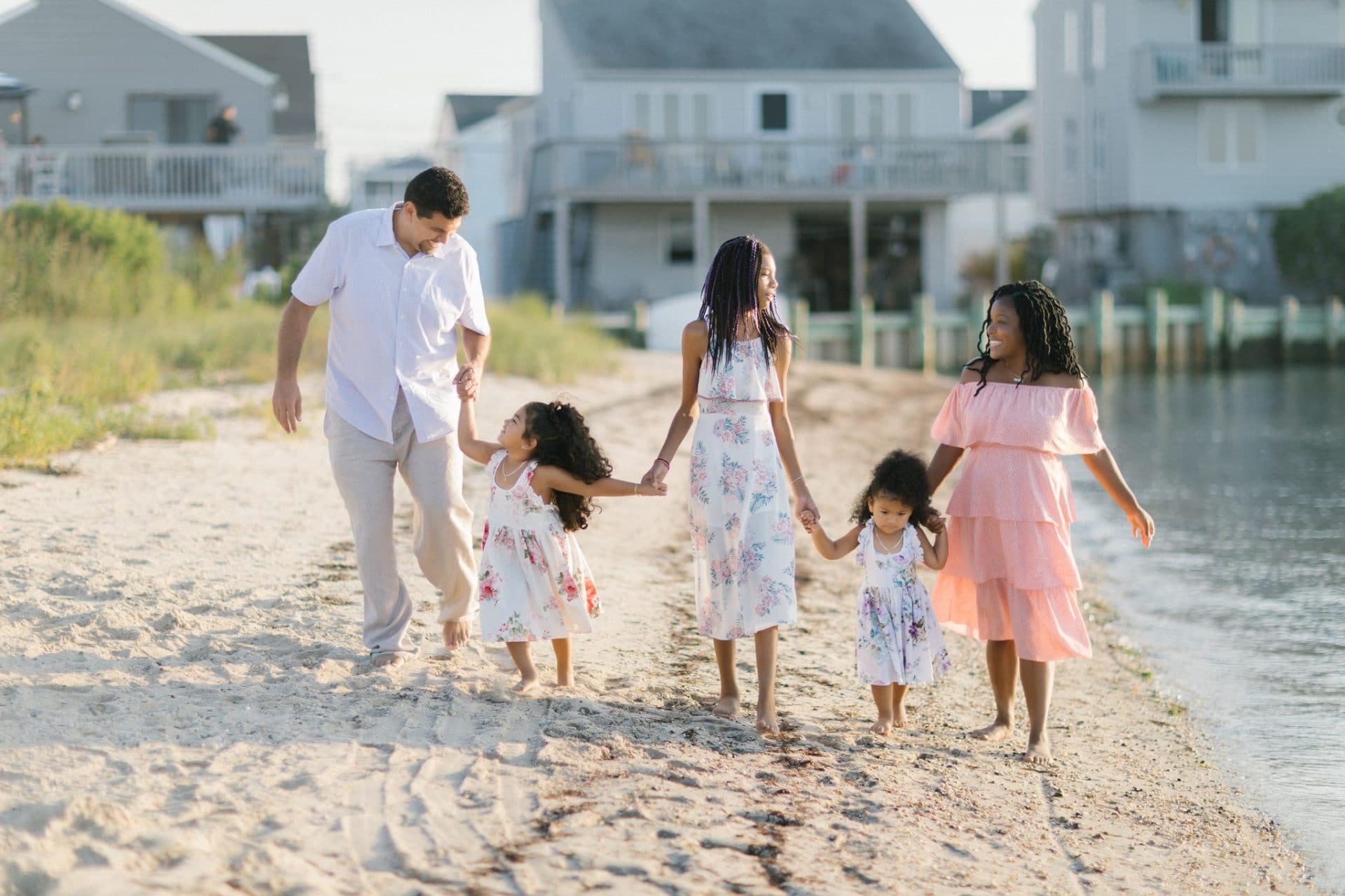 A family of five walking hand in hand along the bay beach in Beach Haven, New Jersey