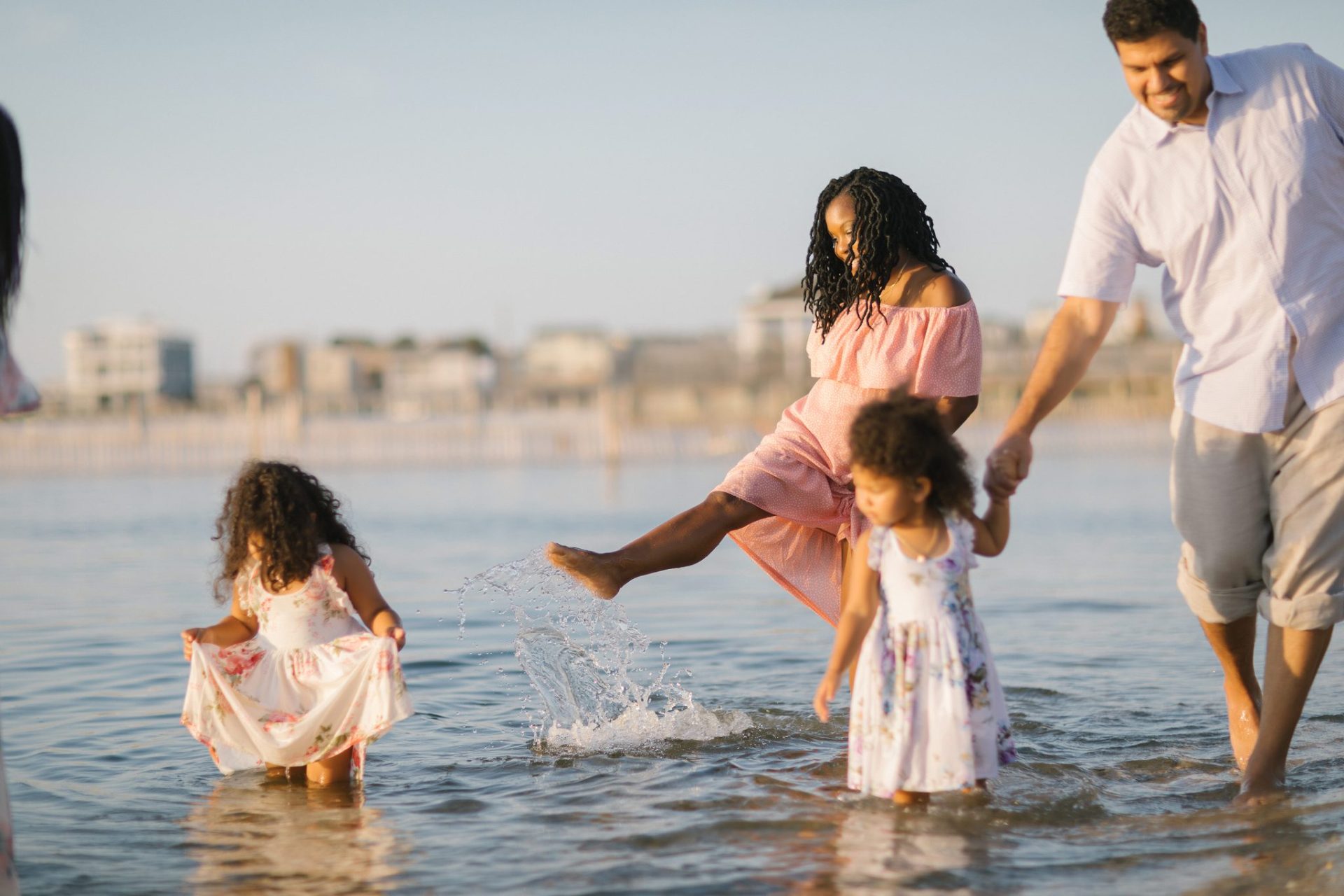 A mother kicking up a splash while holding her daughter's hand in the bay at Beach Haven, New Jersey