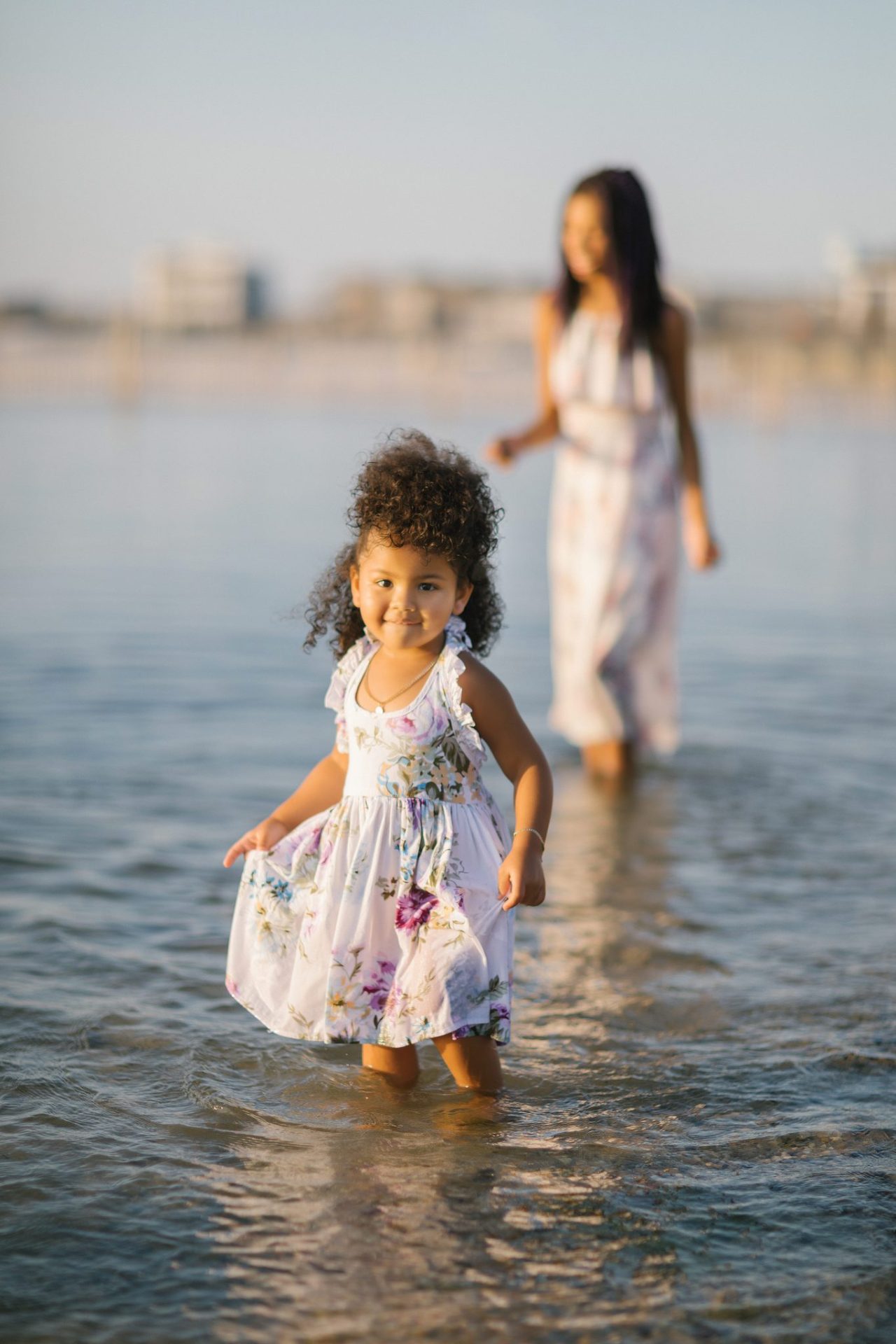 A young girl walking toward the camera through the bay shallows during a Beach Haven family session
