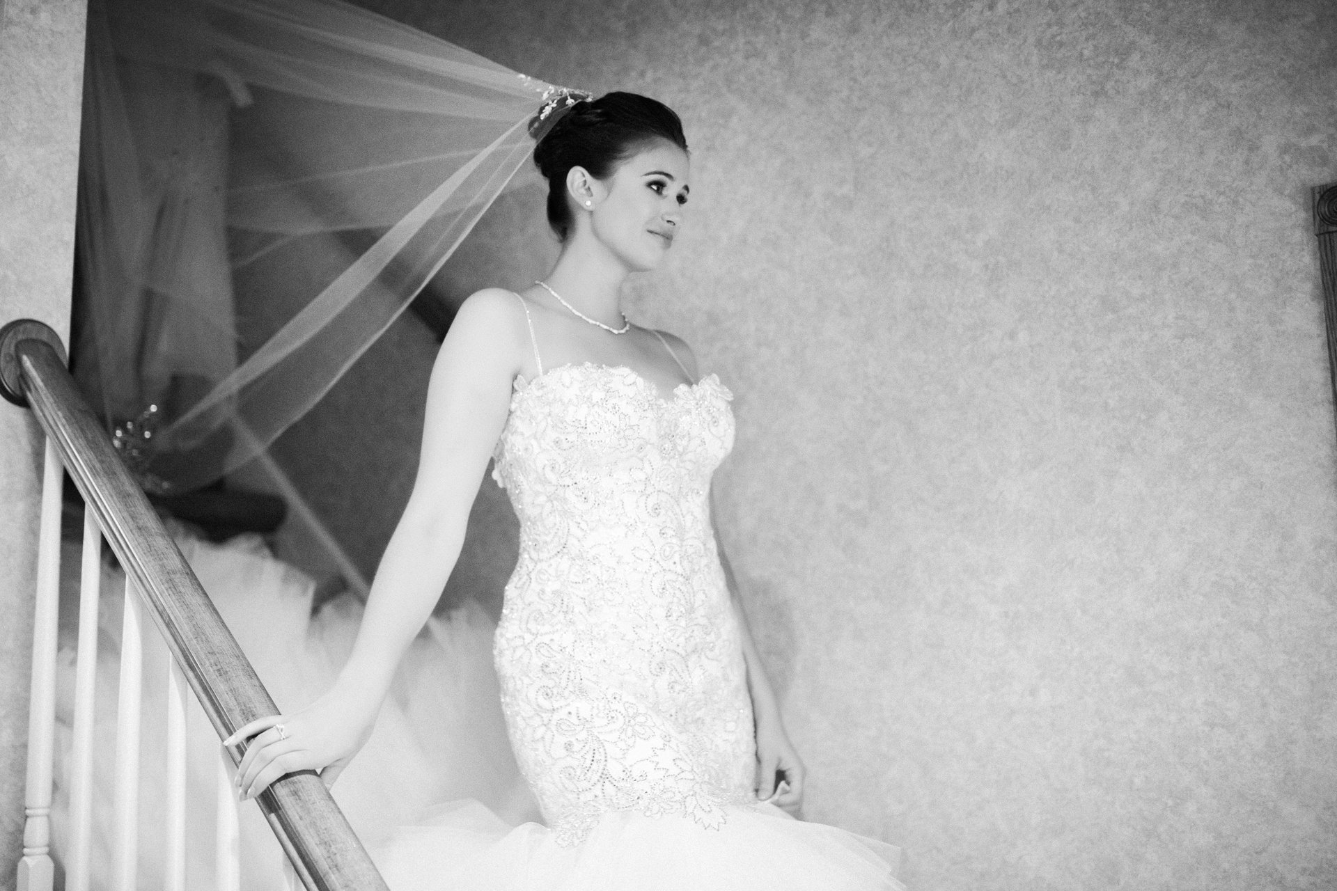 Bride on the staircase of her childhood home in her wedding gown