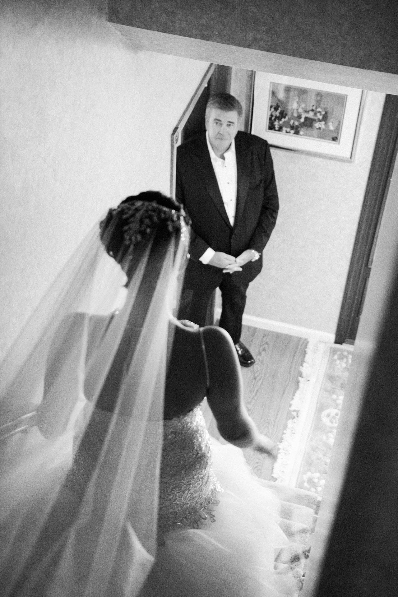 Bride seated in a window with her veil spilling across the floor