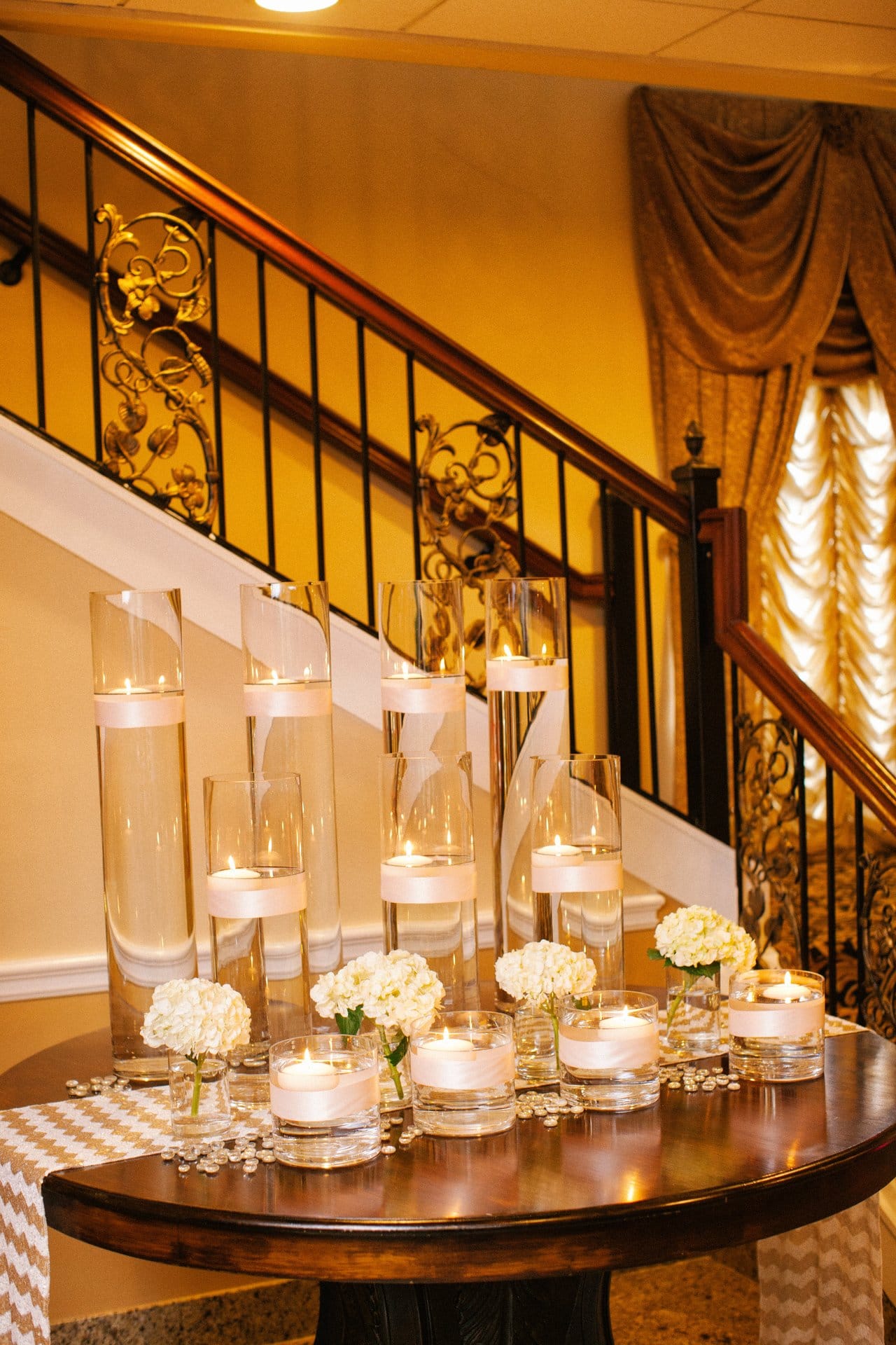 Candles clustered on a table beside the staircase at Lucien's Manor