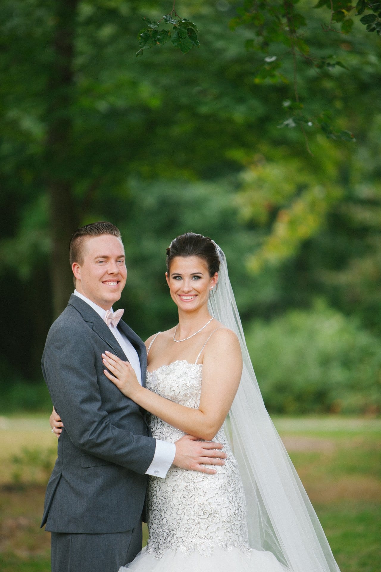 Bride and groom holding each other in the park