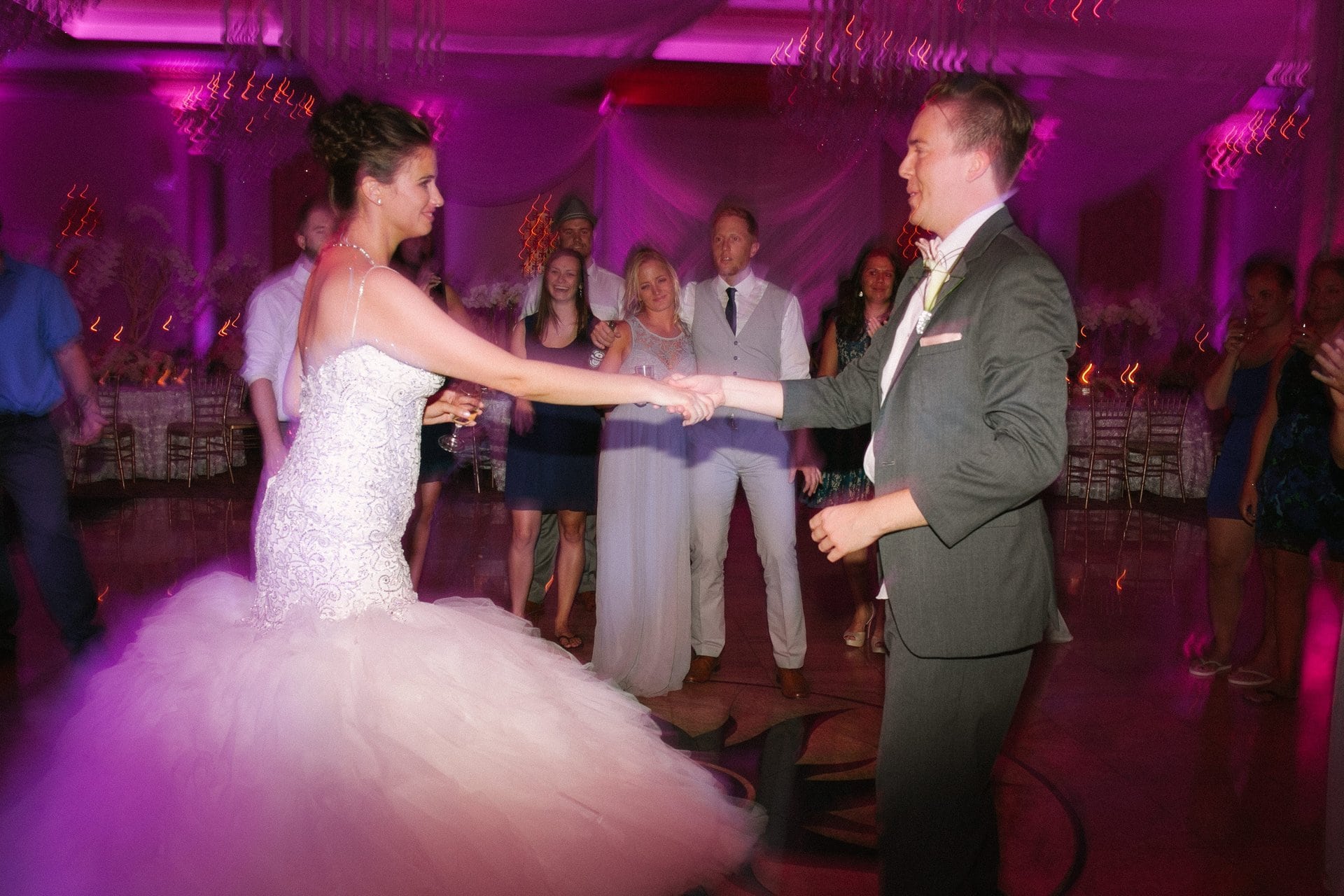 Bride and groom holding hands on the dance floor