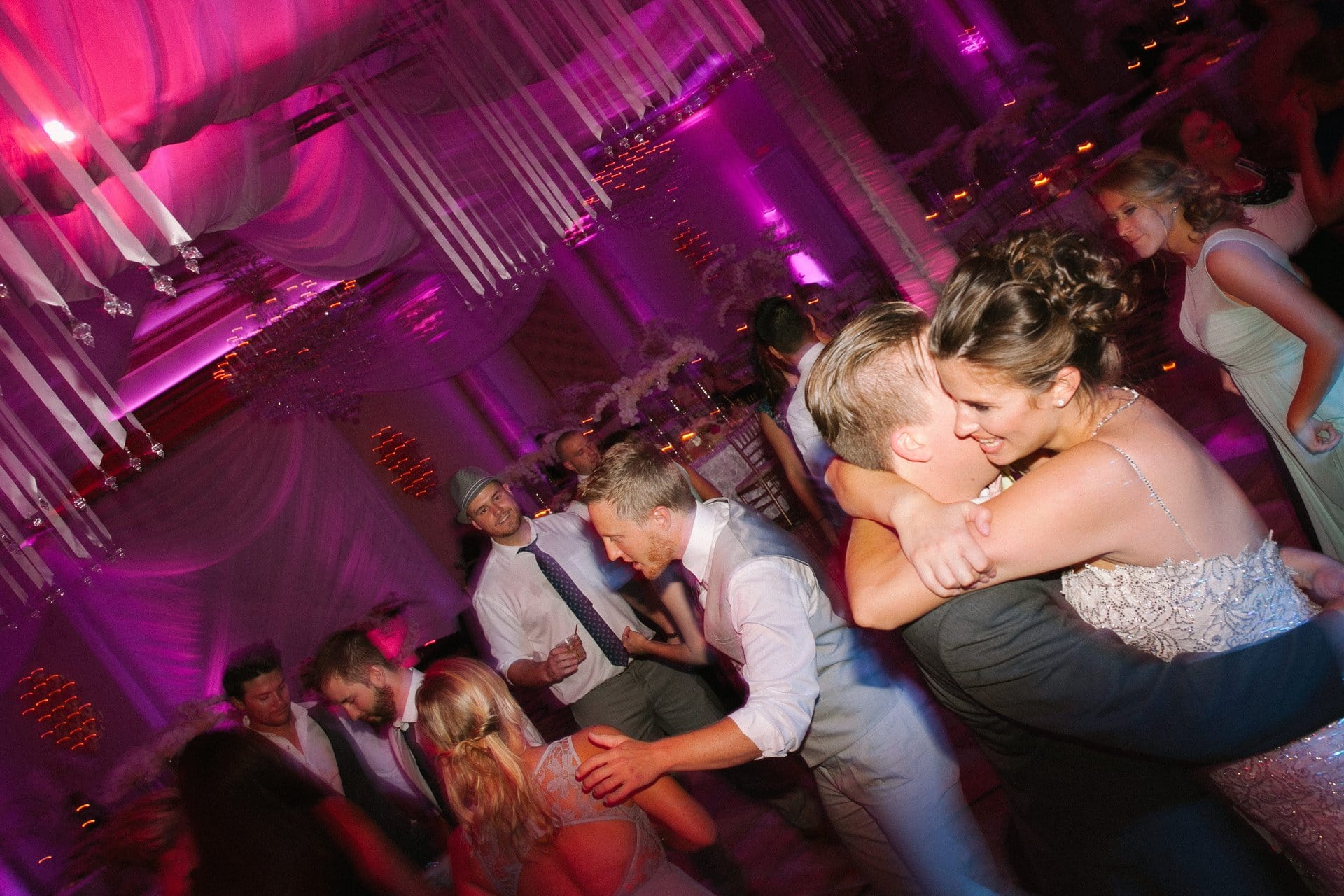 Groom dipping the bride while guests dance around them