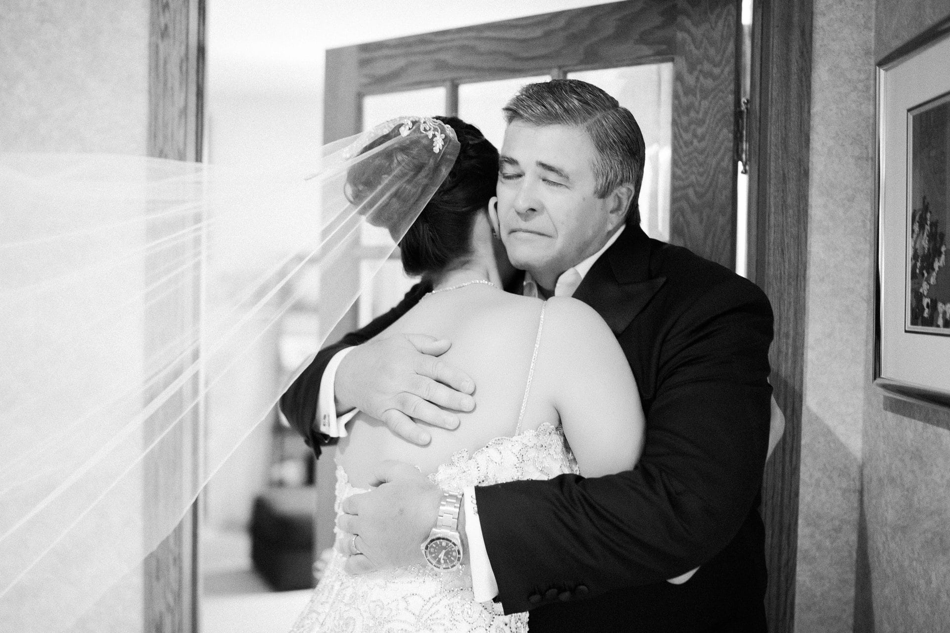 Father of the bride holding his daughter after seeing her in her dress