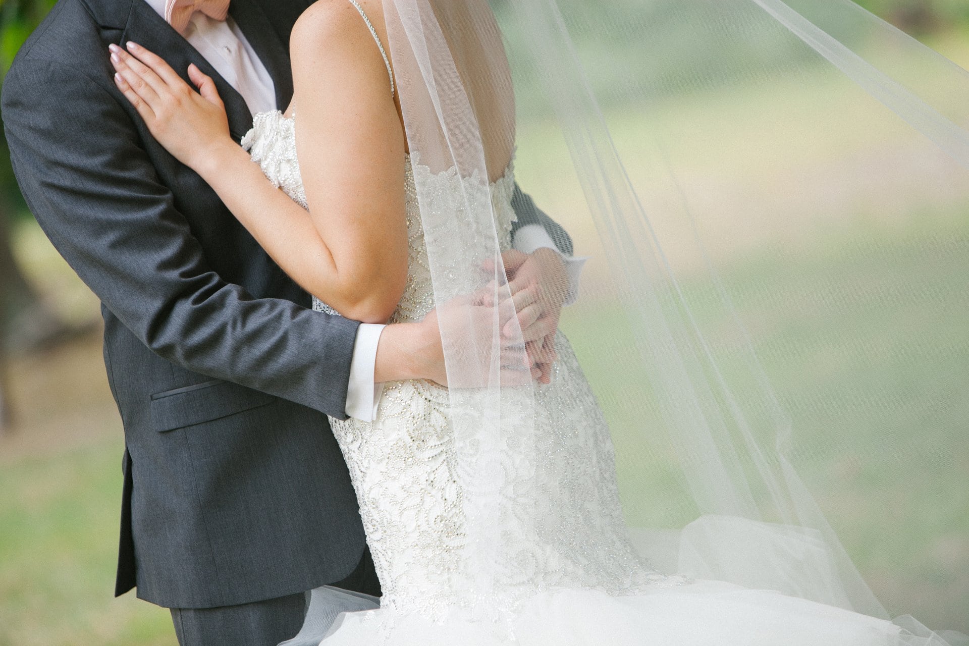 Groom lifting the bride, veil catching the light
