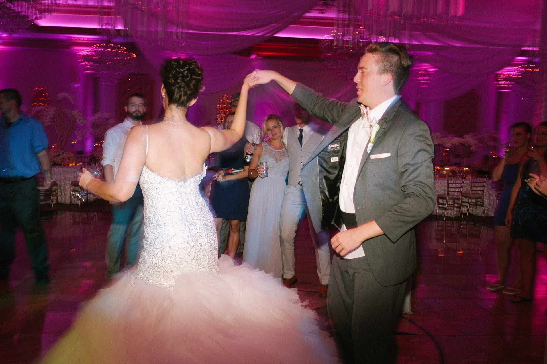 Bride and groom dancing in a packed room