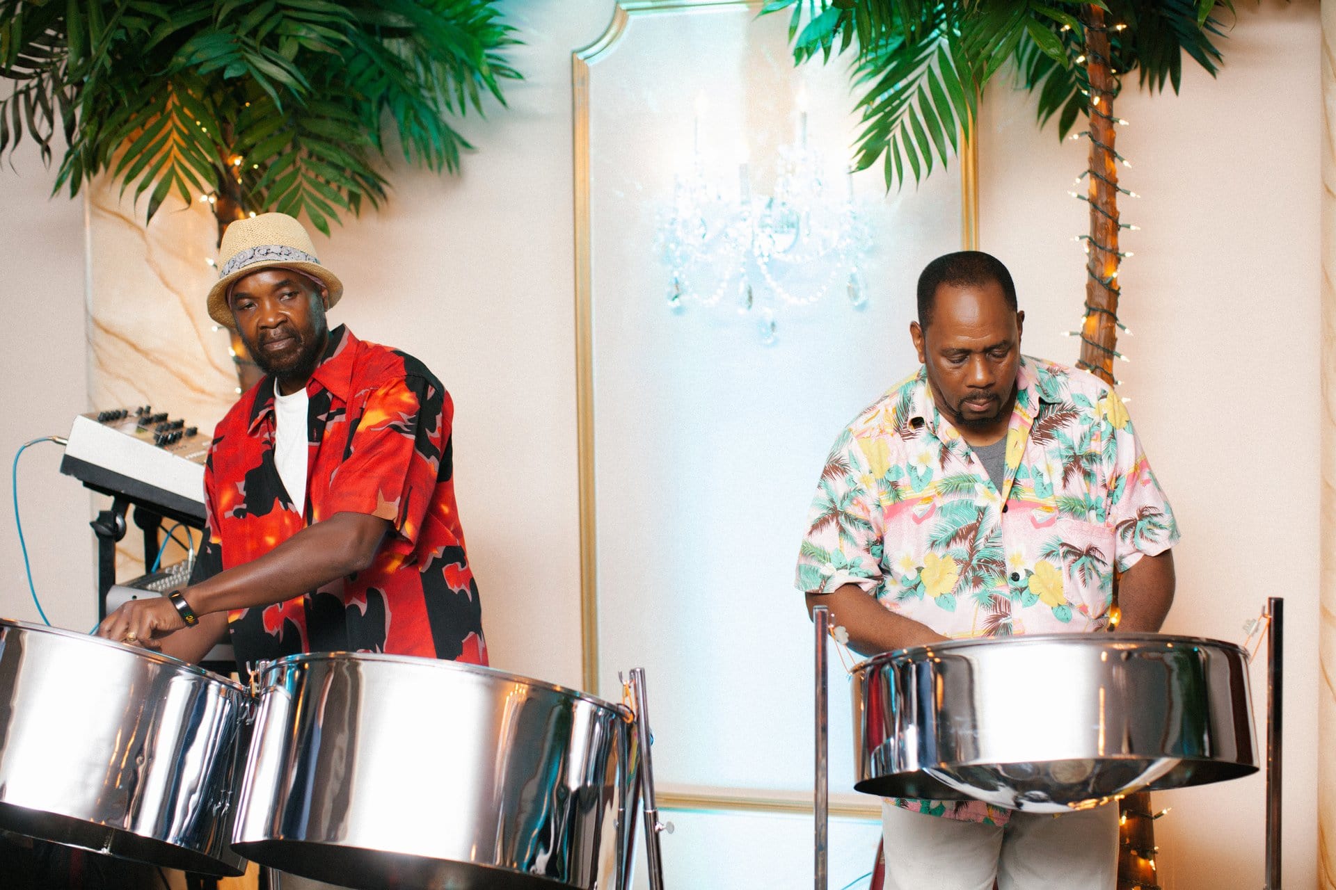 Steel drum duo playing cocktail hour under lit palm trees