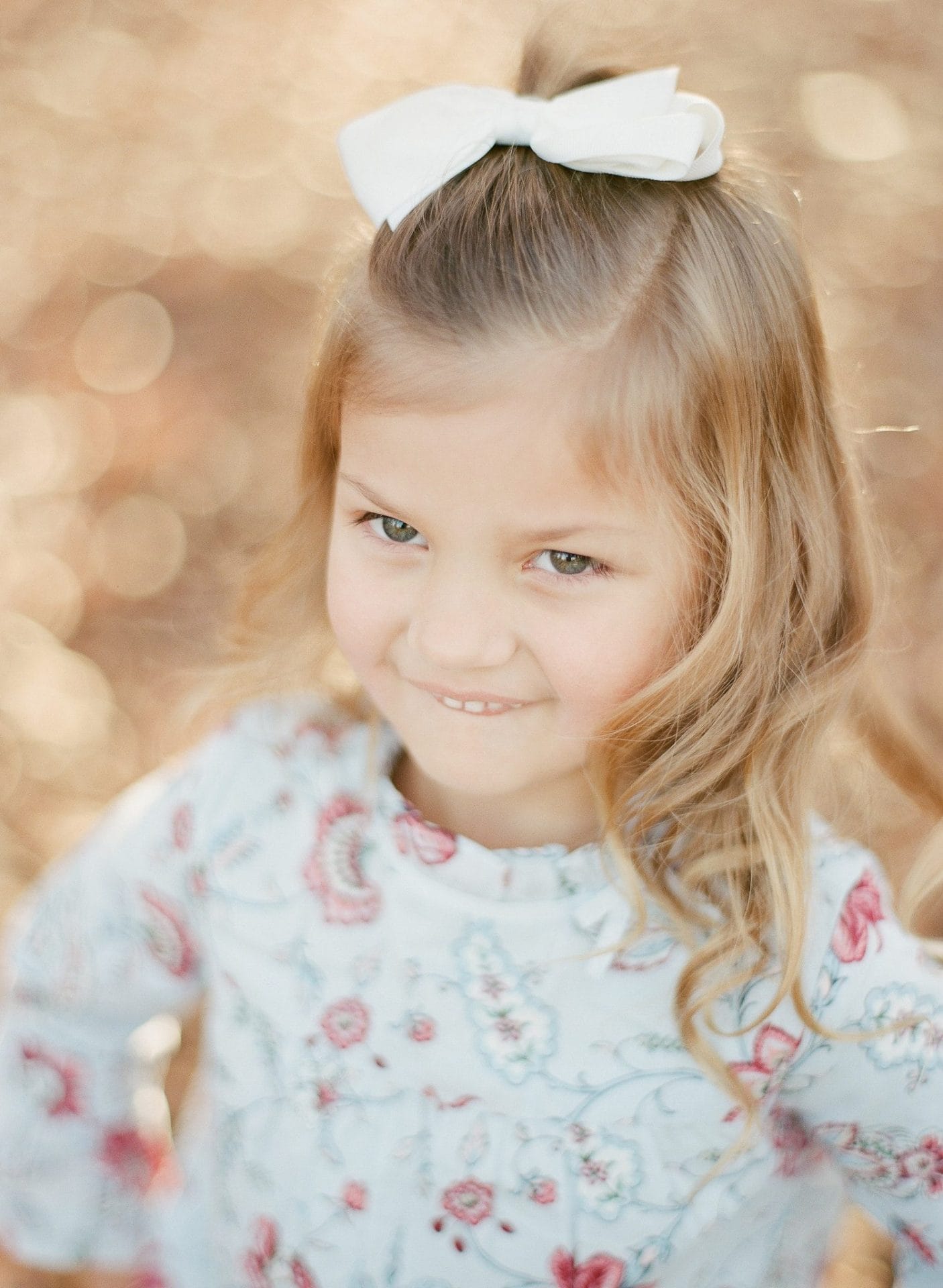 A close portrait of a young girl in a floral top with gold leaves behind her in Medford, New Jersey