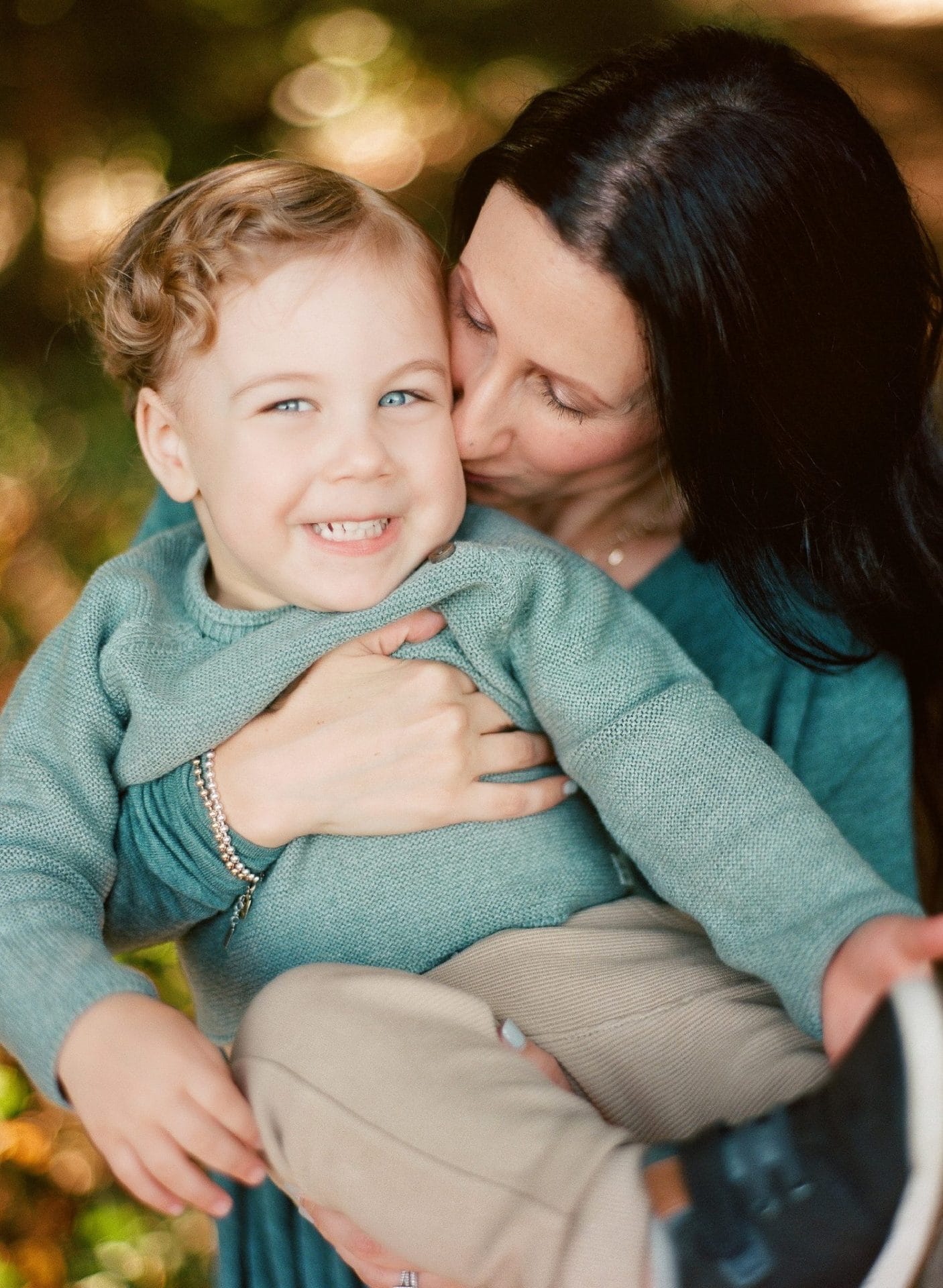 A mom kissing her sons cheek during a family portrait session at Laurel Acres Park in Mount Laurel, New Jersey