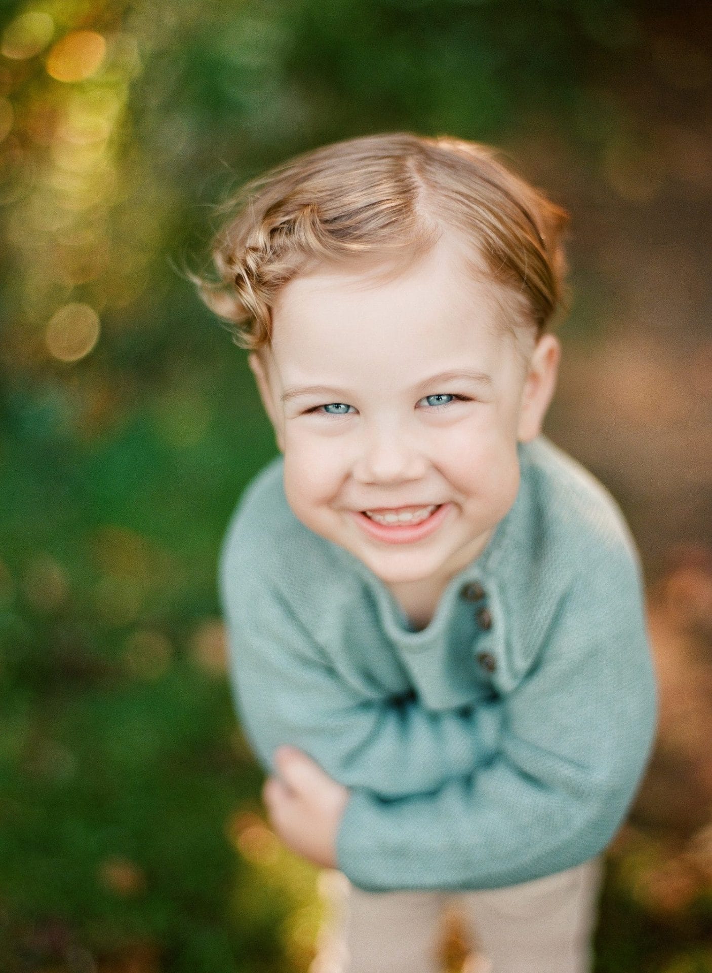 A portrait of a small boy laughing with his shoulders pulled up during a family session in Mount Laurel, New Jersey
