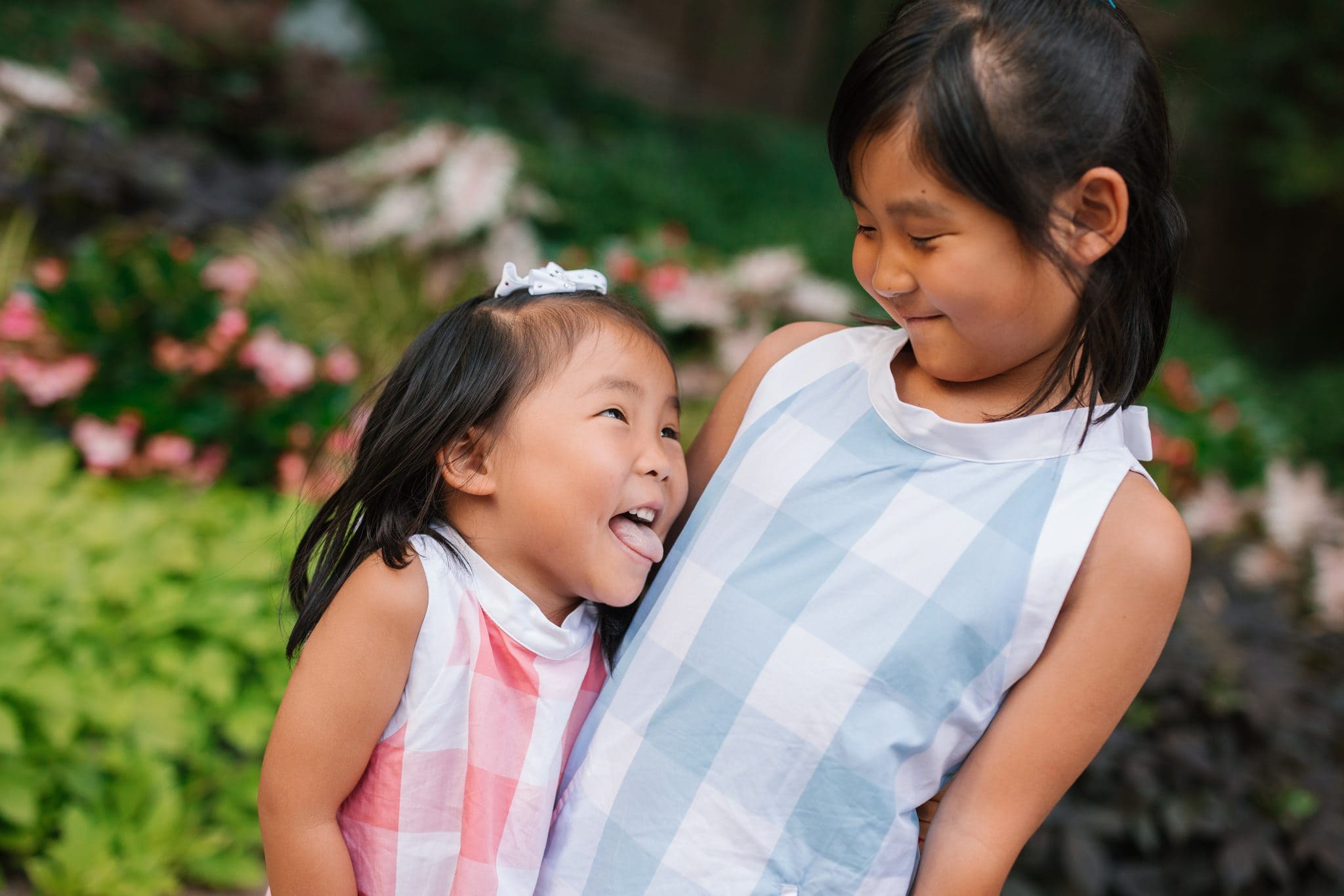 Two young cousins laughing together in the garden courtyard at The Rittenhouse in Philadelphia