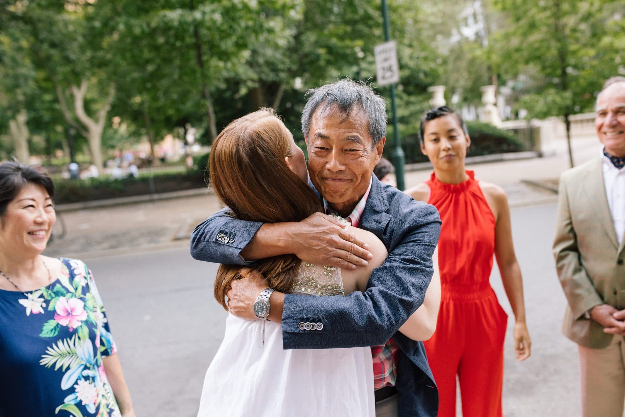 Family members embracing on the street outside The Rittenhouse in Philadelphia after the proposal
