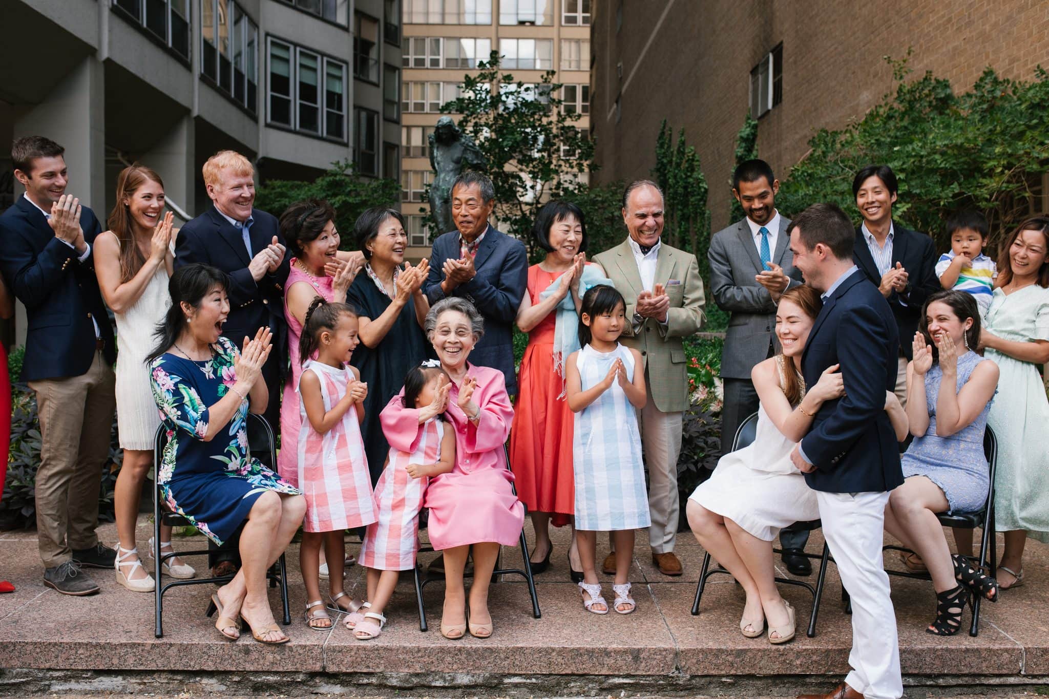 The family clapping and cheering during a surprise proposal at a Philadelphia family reunion
