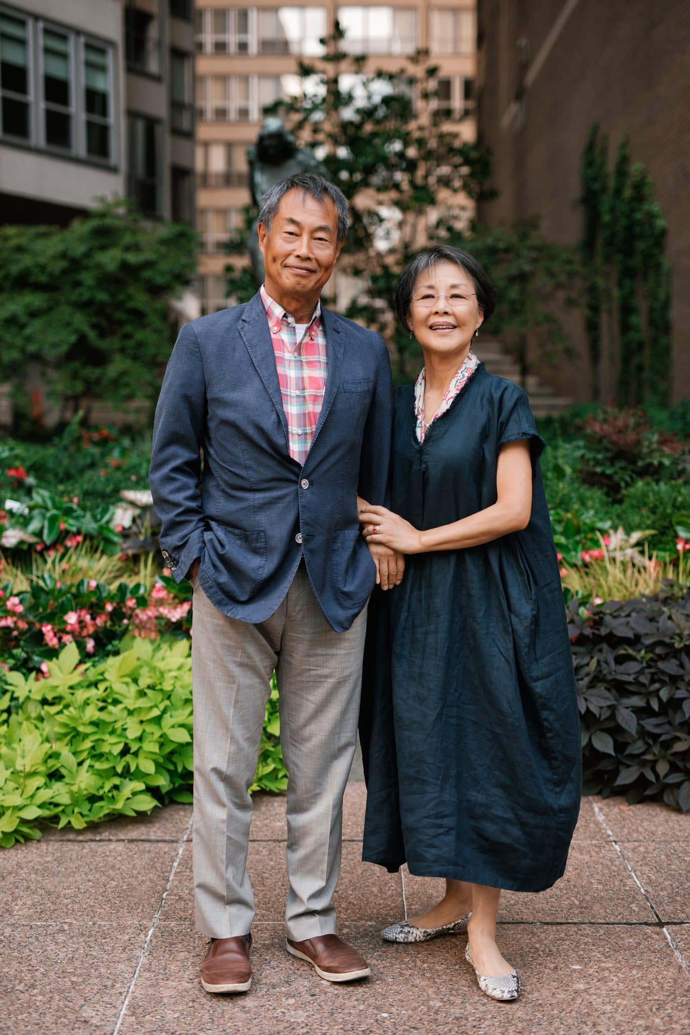 Grandparents standing together among the flowers in the courtyard at The Rittenhouse in Philadelphia