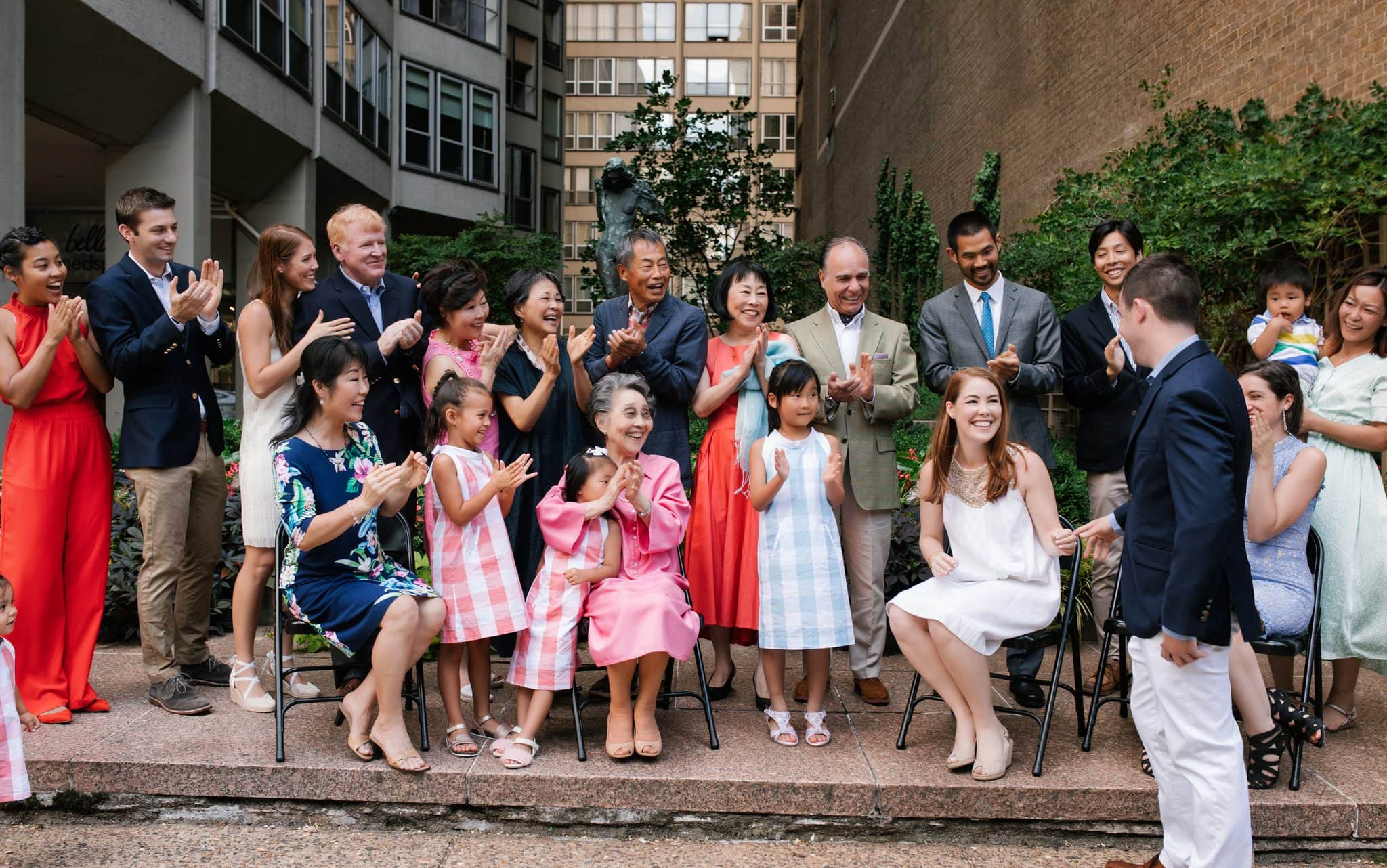 She stands to meet him after saying yes to a surprise proposal in front of her family in Philadelphia